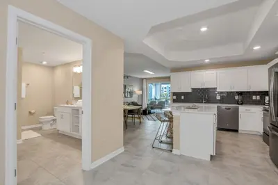 a large kitchen with white cabinets and a dining room at 3180 Para unit 101 townhouse in Kissimmee