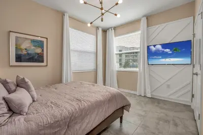 a bedroom with a large bed and a large window at 3180 Para unit 101 townhouse in Kissimmee