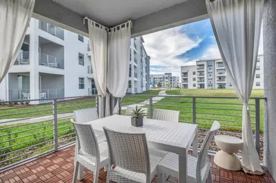 a patio with a white table and chairs on a balcony at 3180 Para unit 101 townhouse in Kissimmee