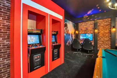 a video game room with a red wall at Amazing 15 Bedroom house at Veranda Palms 2395RAMA villa in Kissimmee