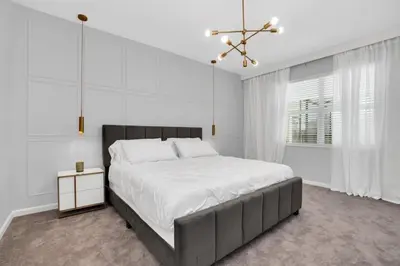 a white bedroom with a large bed and a chandelier at Amazing 15 Bedroom house at Veranda Palms 2395RAMA villa in Kissimmee