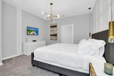 a white bedroom with a large bed and a tv at Amazing 15 Bedroom house at Veranda Palms 2395RAMA villa in Kissimmee