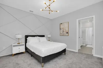 a white bedroom with a bed and a chandelier at Amazing 15 Bedroom house at Veranda Palms 2395RAMA villa in Kissimmee