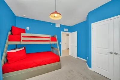 a blue room with two bunk beds with red pillows at 4741Clock Unit208 townhouse in Kissimmee