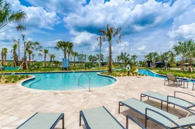 a pool at the resort with benches and palm trees at 4741Clock Unit208 townhouse in Kissimmee