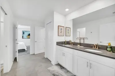 a white bathroom with two sinks and a bedroom at 2900Penolpe home in Kissimmee