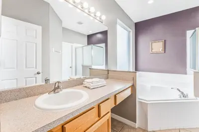 a bathroom with a sink and a large mirror at Emerald Island Large 8 Bed Home Golf Resort villa in Kissimmee