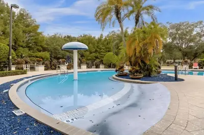 a pool at a resort with palm trees at Casa 3Q West Lucaya – Perto da Disney c/ Clubhouse in Kissimmee