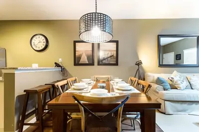 a dining room with a table and a couch at Casa 3Q West Lucaya – Perto da Disney c/ Clubhouse in Kissimmee