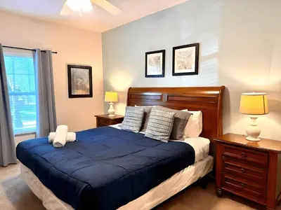 a bedroom with a bed with a blue comforter at Casa 3Q West Lucaya – Perto da Disney c/ Clubhouse in Kissimmee