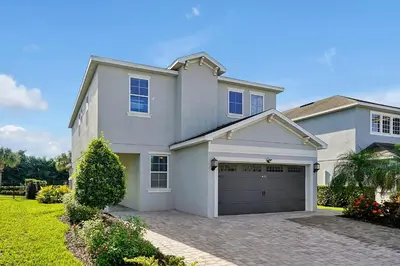 a large white house with a garage at 5BD Moana-Themed - Movie by the Pool - Near Disney in Orlando