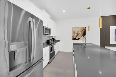 a kitchen with a stainless steel refrigerator and a counter at Luxury 4 Bedroom Storey Lake Townhome 2444Reading townhouse in Kissimmee