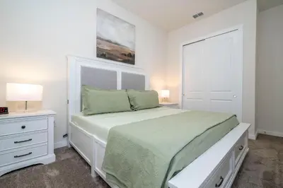 a white bedroom with a bed and two night stands at RCT Dreamstay in Orlando