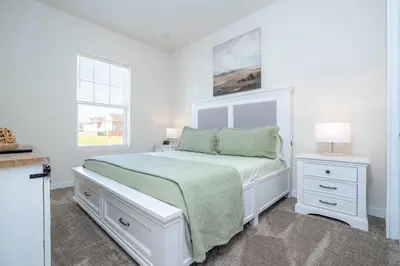 a white bedroom with a bed and two night stands at RCT Dreamstay in Orlando