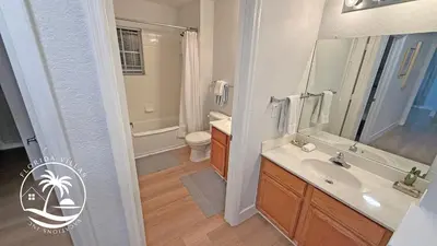 a bathroom with a sink and a toilet and a mirror at Deluxe 4 bedrooms Villa at Seven Dwrafs Resort - Close to Disney in Kissimmee