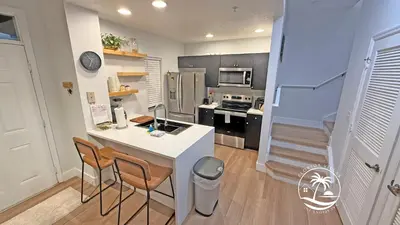 a kitchen with a counter and two chairs and a island at Deluxe 4 bedrooms Villa at Seven Dwrafs Resort - Close to Disney in Kissimmee