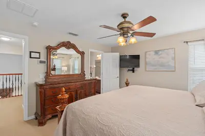 a bedroom with a bed and a mirror and a ceiling fan at Mickeys Sunrise - Phenomenal 7BR Themed Rooms Home Theater Swingset SplashPad Gas BBQ - 2 miles to Disney in Orlando
