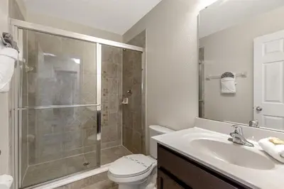 a bathroom with a shower and a toilet and a sink at 299- Fabulous 4 Bed Modern Decor Villa with Private Pool Overlooking Conservation and Water View in Kissimmee