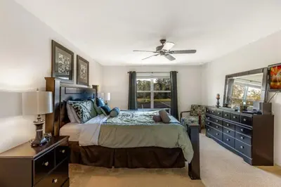 a bedroom with a large bed and a dresser at 299- Fabulous 4 Bed Modern Decor Villa with Private Pool Overlooking Conservation and Water View in Kissimmee