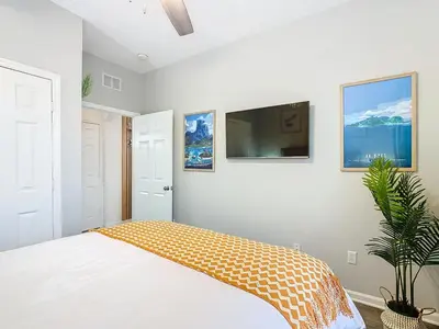 a bedroom with a bed and a tv on a wall at Windsor Hills Cozy 3 BR Condo, Starwars, By Disney in Orlando