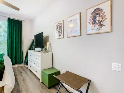 a bedroom with a tv and a desk with a chair at Windsor Hills Cozy 3 BR Condo, Starwars, By Disney in Orlando