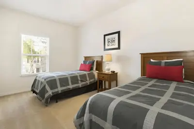 a bedroom with two beds and a window at Casa 3Q em Resort Fechado – A Minutos da Disney in Kissimmee