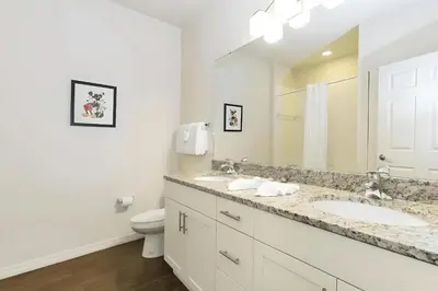 a white bathroom with two sinks and a toilet at Casa 3Q em Resort Fechado – A Minutos da Disney in Kissimmee
