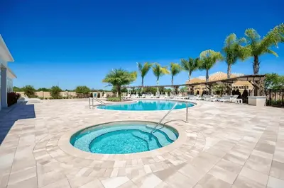 a swimming pool in a patio with palm trees at Casa 3Q em Resort Fechado – A Minutos da Disney in Kissimmee