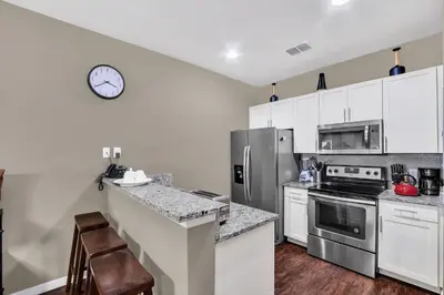 a kitchen with white cabinets and a clock on the wall at Casa 3Q West Lucaya c/ Piscina – Perto da Disney in Kissimmee
