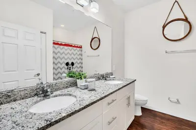 a bathroom with two sinks and a toilet at Casa 3Q West Lucaya c/ Piscina – Perto da Disney in Kissimmee