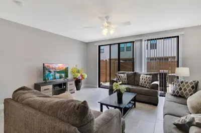 a living room with two couches and a tv at Spectacular! Townhome 9 Miles to Disney World! in Kissimmee