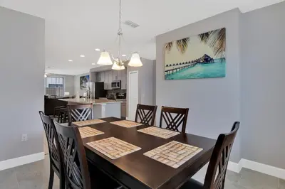 a dining room and kitchen with a table and chairs at Spectacular! Townhome 9 Miles to Disney World! in Kissimmee