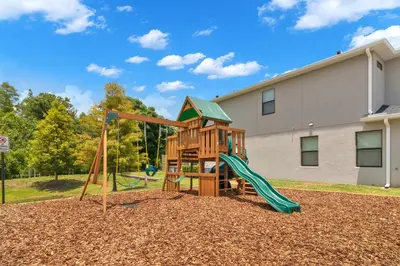 a playground with a slide in a yard at Spectacular! Townhome 9 Miles to Disney World! in Kissimmee