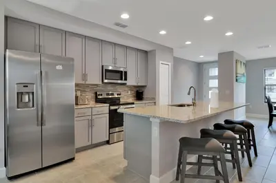a kitchen with a stainless steel refrigerator and cabinets at Spectacular! Townhome 9 Miles to Disney World! in Kissimmee