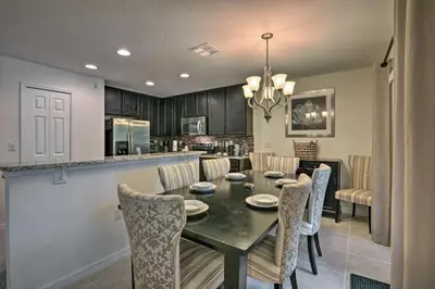 a kitchen and dining room with a table and chairs at Look over Nature, Pool Home Near Disney Parks in Kissimmee