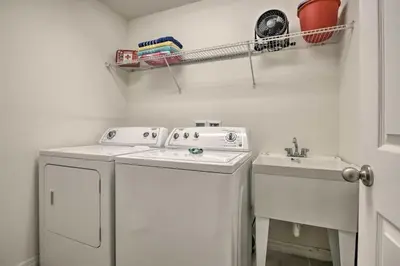 a white laundry room with a washer and a sink at Look over Nature, Pool Home Near Disney Parks in Kissimmee