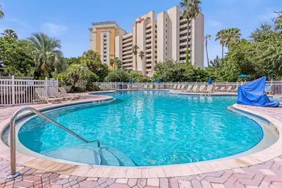 a swimming pool with chairs and buildings in the background at 22 -The heart of International Dr - Universal in Orlando