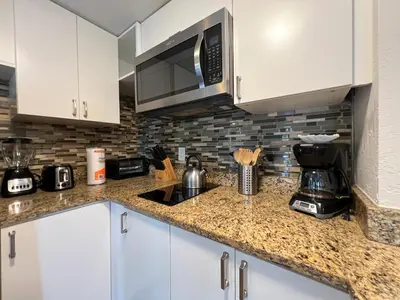 a kitchen with white cabinets and a microwave at 22 -The heart of International Dr - Universal in Orlando