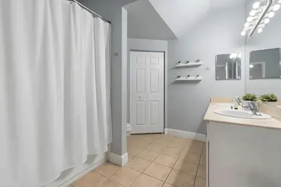a bathroom with a white shower curtain and a sink at Casa 3Q/2B – Região Disney com Piscina Privada in Kissimmee