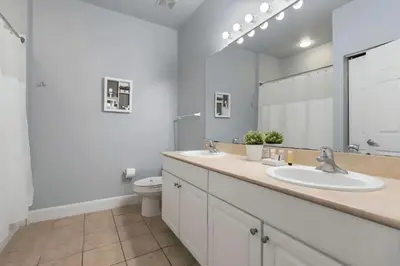 a bathroom with two sinks and a toilet at Casa 3Q/2B – Região Disney com Piscina Privada in Kissimmee