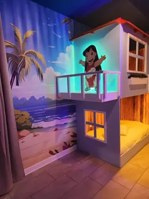 a room with a toy house with a disney mural at Casa 7Q perto da Disney com Piscina e Games in Kissimmee