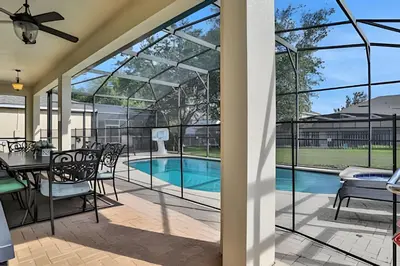a patio with a table and chairs and a swimming pool at Casa 6Q Familiar c/ Game Room Marvel e Piscina in Orlando