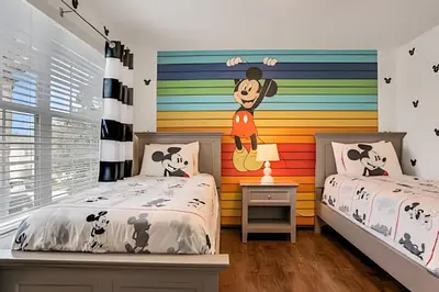 a childs bedroom with two beds and a colorful wall at Casa 6Q Familiar c/ Game Room Marvel e Piscina in Orlando