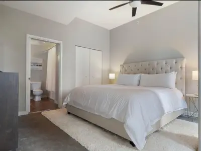 a white bedroom with a large bed with a ceiling fan at Extra Large 1 Bdrm Condo & Gym in Orlando