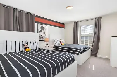 two beds in a bedroom with black and white stripes at Casa Resort com Piscina Aquecida e Pingue-Pongue in Kissimmee