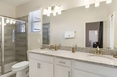 a bathroom with two sinks and a toilet and a shower at Casa Resort com Piscina Aquecida e Pingue-Pongue in Kissimmee