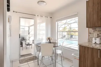 a kitchen and dining room with a table and chairs at 3Q/2B Vista para o Lago c/piscina | 10min->Disney in Kissimmee
