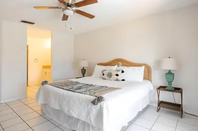 a bedroom with a white bed with a ceiling fan at 3Q/2B Vista para o Lago c/piscina | 10min->Disney in Kissimmee
