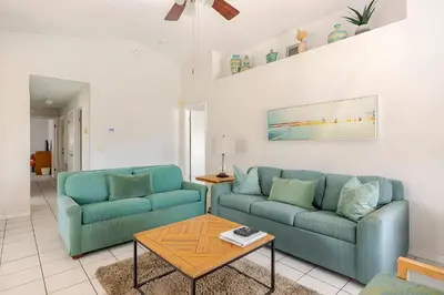 a living room with two blue couches and a table at 3Q/2B Vista para o Lago c/piscina | 10min->Disney in Kissimmee