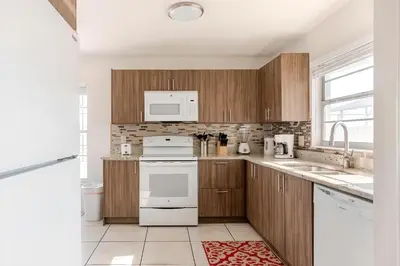 a kitchen with wooden cabinets and white appliances at 3Q/2B Vista para o Lago c/piscina | 10min->Disney in Kissimmee